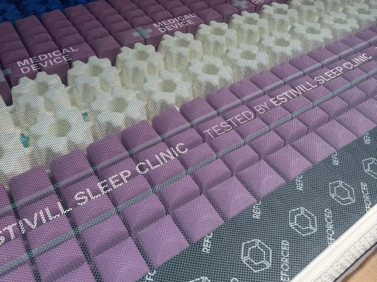Colchón viscoelástico Gomarco con la capa superior levantada, que deja ver el núcleo de espuma viscoelástica y la marca Estivill Sleep Clinic