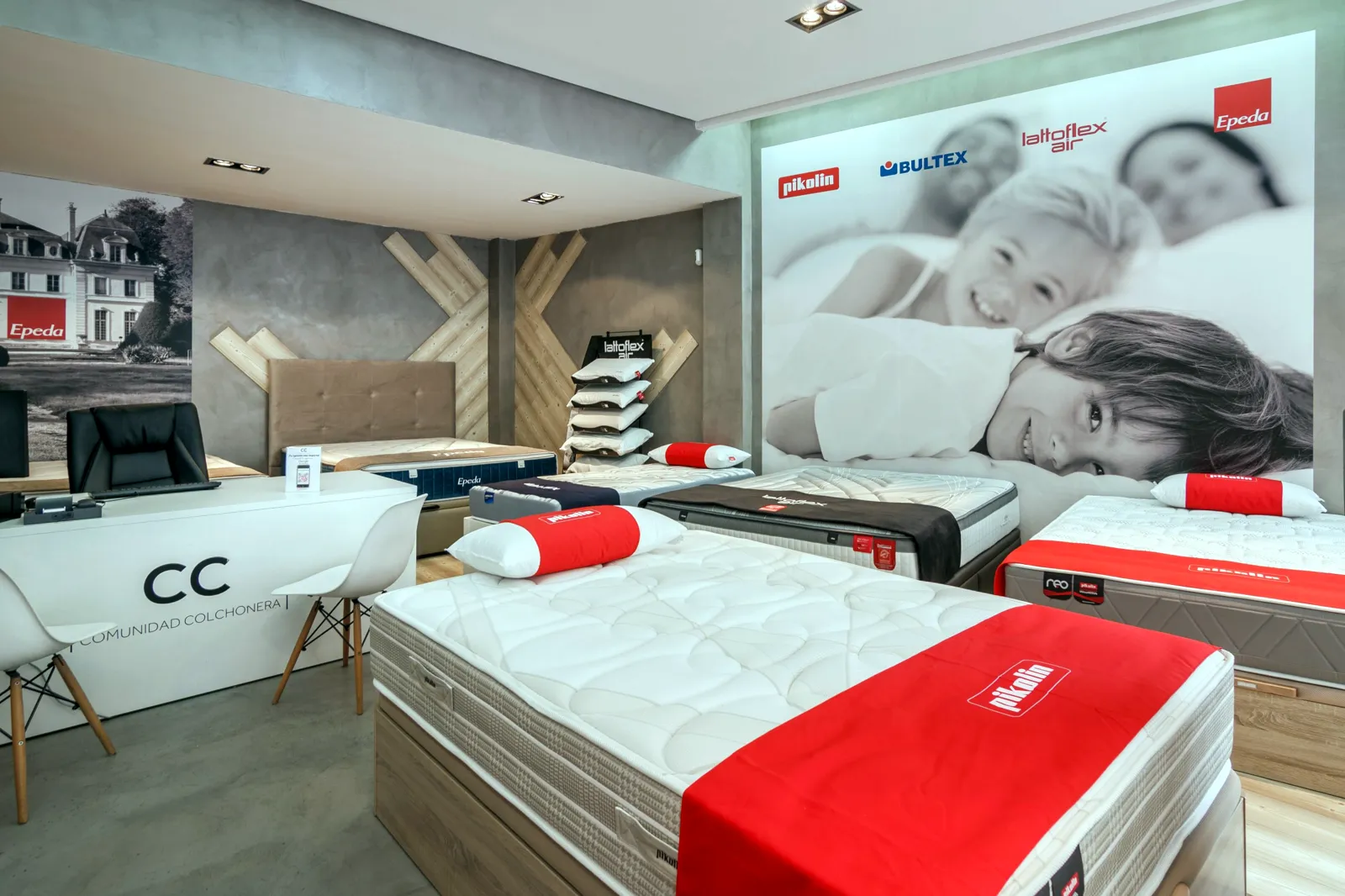 Colchones, canapés y almohadas Pikolin junto a la pared de marcas en la tienda Comunidad Colchonera de Cartagena