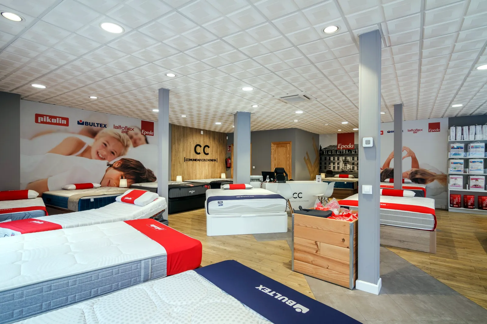 Exposición de colchones y canapés con las paredes de marcas de Pikolin, Bultex, Lattoflex y Epeda en la tienda Comunidad Colchonera de Getafe