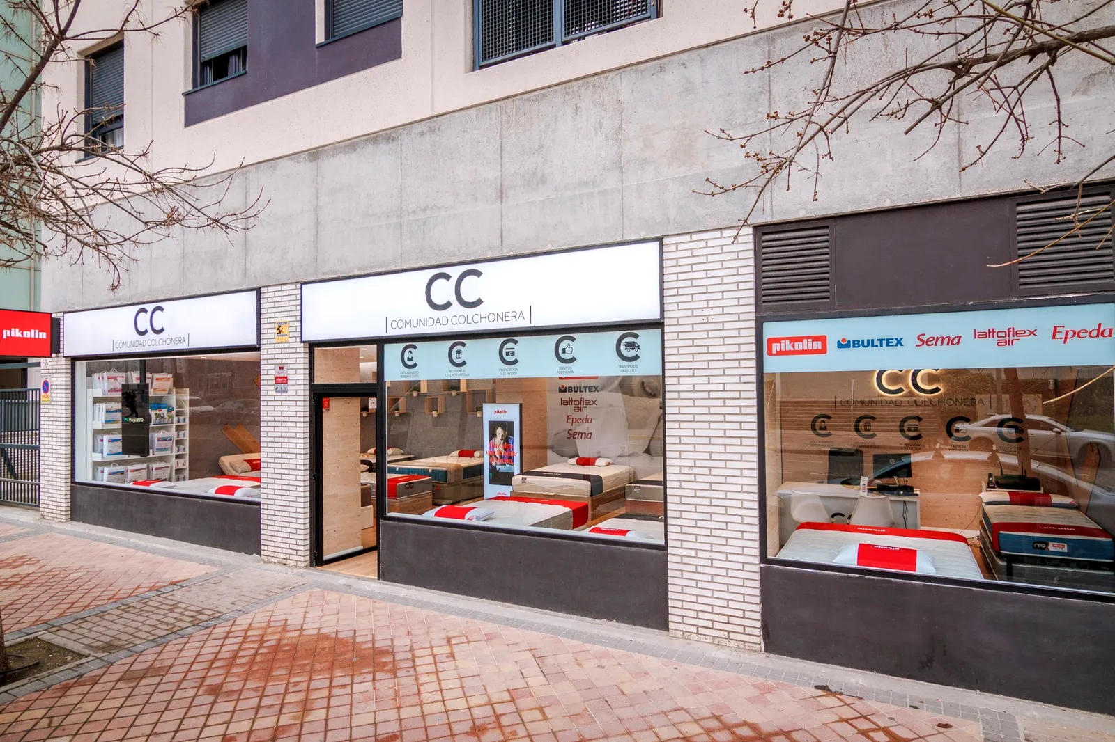 Fachada de la tienda Comunidad Colchonera de La Gavia, en la Avenida de las Suertes, con los escaparates de colchones y el rótulo de Pikolin