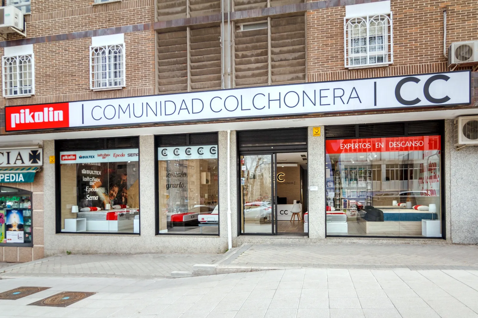 Fachada de la tienda Comunidad Colchonera en C/ del Camino de los Vinateros, 70, Moratalaz, Madrid, con el rótulo de Pikolin y los escaparates de colchones