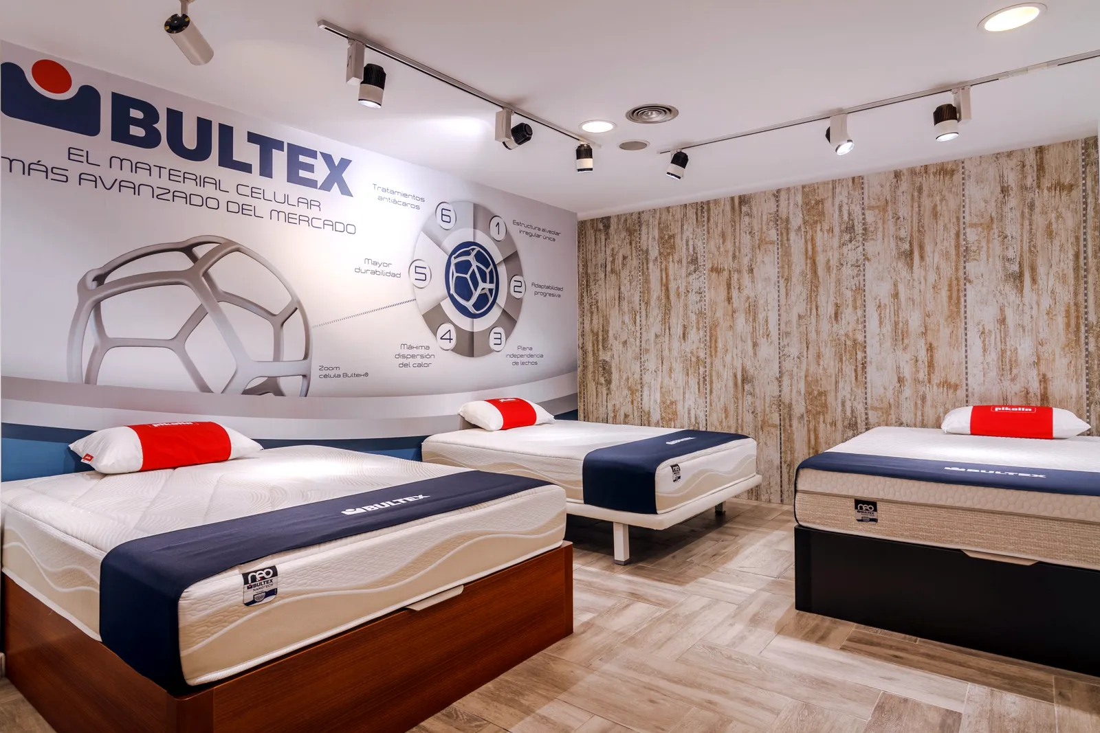 Espacio de marca Bultex con gran mural y tres camas con colchones Bultex y Pikolin en la tienda Comunidad Colchonera de Moratalaz, Madrid